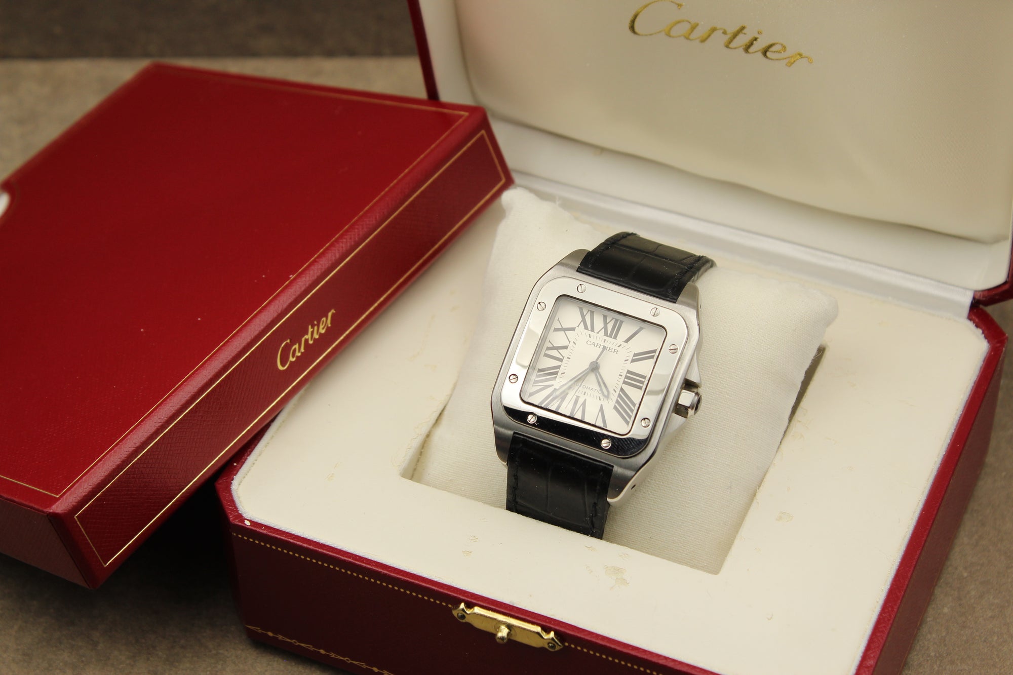 Montre Cartier Santos 100 pour homme en acier, vendue par prestigeandtime.com, présentée en occasion authentique en excellent état avec full set, modèle emblématique idéal pour collection ou investissement horloger.